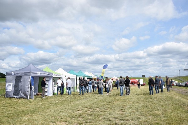 Namioty firm wystawiających się na Dniach Pola 2022. Przy namiotach dyskutujący przedstawiciele i rolnicy